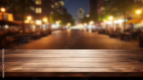 Wooden table is placed in front of city street at night. This image can be used to depict urban nightlife or as background for city-themed content.