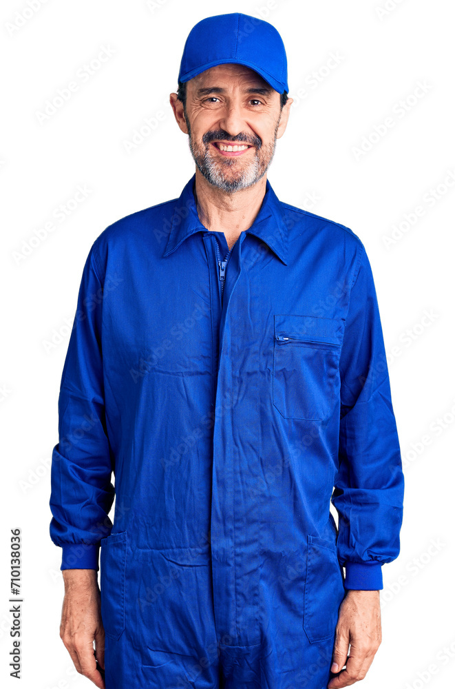 Middle age handsome man wearing mechanic uniform with a happy and cool smile on face. lucky person.