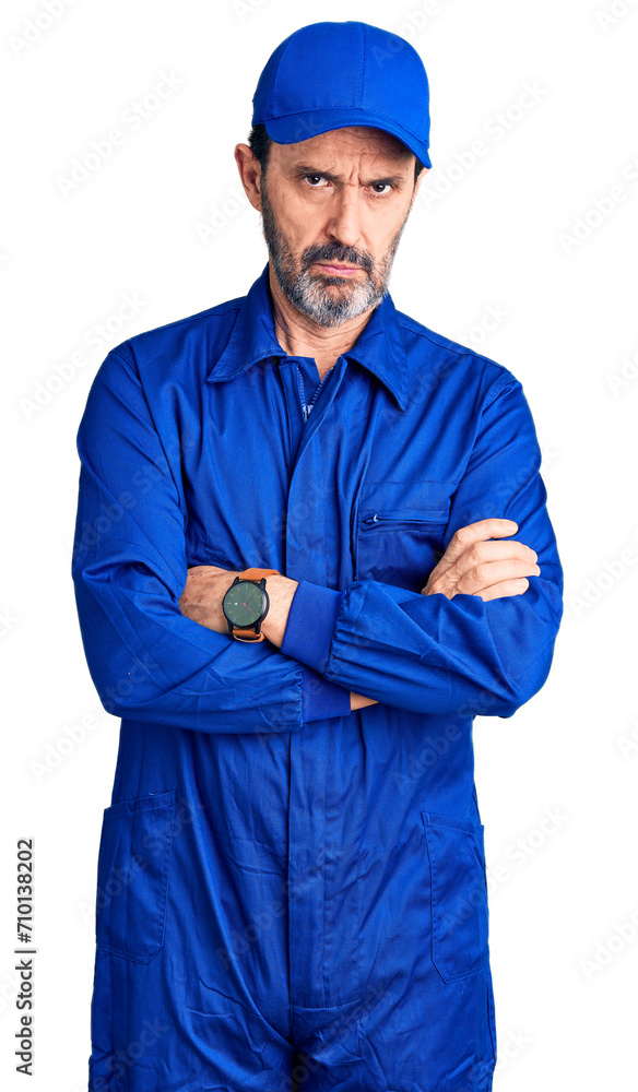 Middle age handsome man wearing mechanic uniform skeptic and nervous, disapproving expression on face with crossed arms. negative person. Middle age handsome man wearing mechanic uniform skeptic and nervous, disapproving expression on face with crossed arms. negative person.
