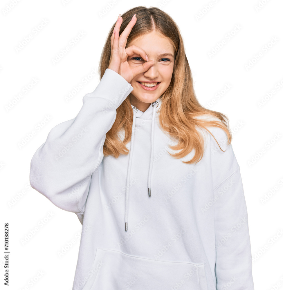 Beautiful young caucasian girl wearing casual sweatshirt doing ok gesture with hand smiling, eye looking through fingers with happy face. Beautiful young caucasian girl wearing casual sweatshirt doing ok gesture with hand smiling, eye looking through fingers with happy face.