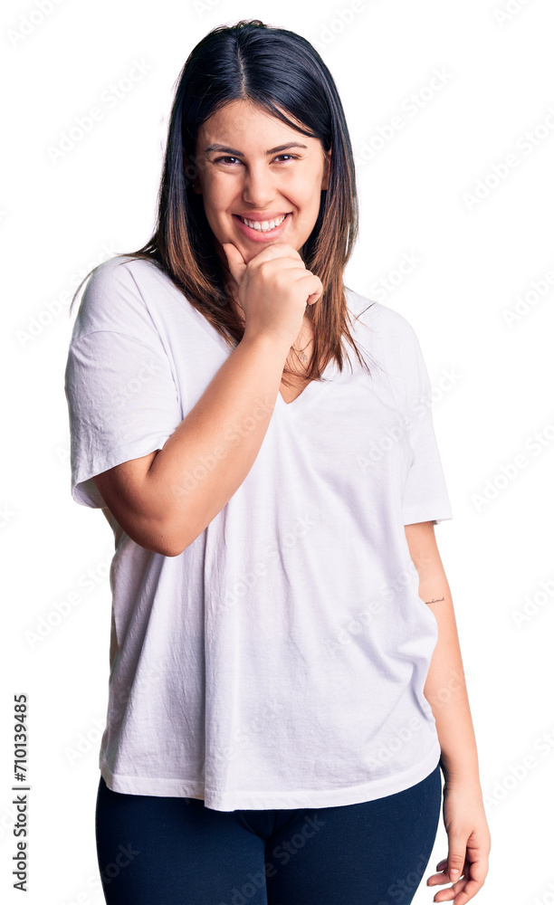 Young beautiful brunette woman wearing casual t-shirt looking confident at the camera smiling with crossed arms and hand raised on chin. thinking positive. Young beautiful brunette woman wearing casual t-shirt looking confident at the camera smiling with crossed arms and hand raised on chin. thinking positive.