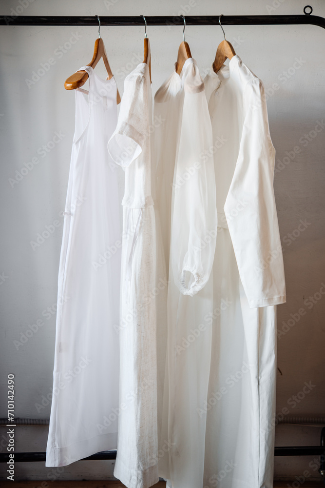 White women's clothing on hangers in a retail shop. Fashion and shopping concept. White women's clothing on hangers in a retail shop. Fashion and shopping concept.