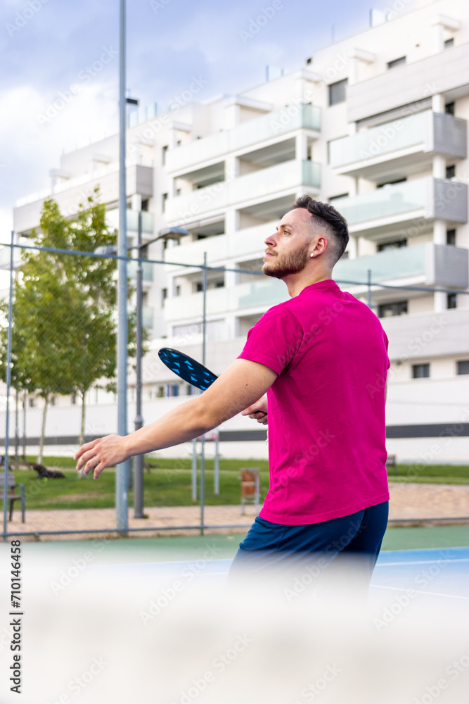 Vertical portrait of a pickleball player preparing to hit the ball.