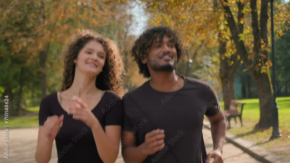 Arabian Indian Caucasian multiracial couple running together in city outdoors happy woman man jogging active healthy lifestyle morning run in park two jogger runners fit sport female male jog outside