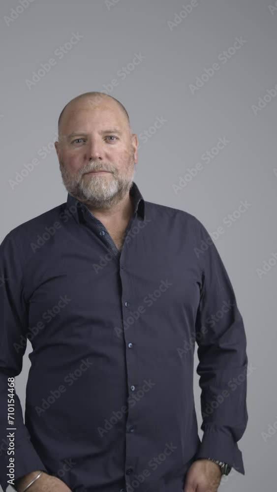 Portrait of well dressed man in studio with positive attitude looking into camera.