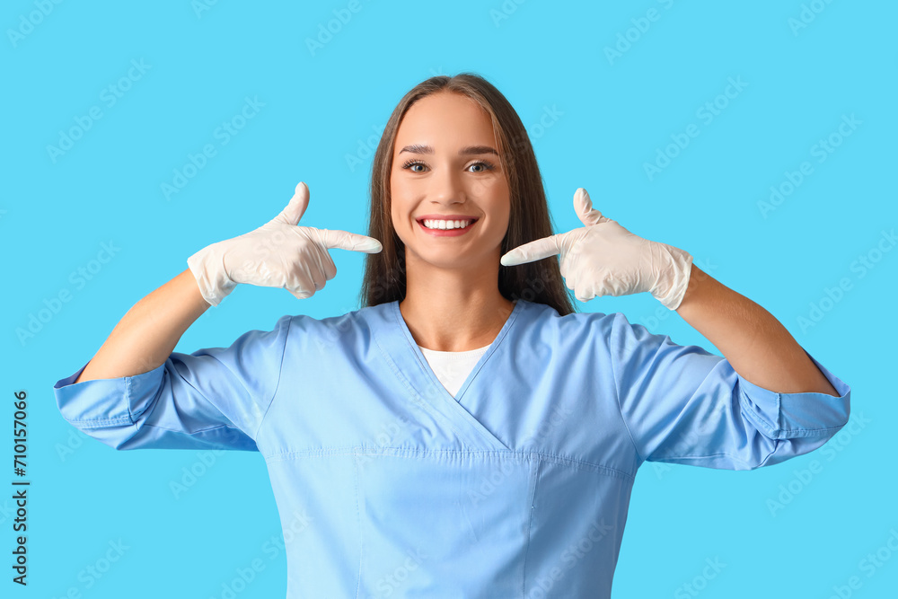 Smiling female dentist with healthy teeth on blue background Smiling female dentist with healthy teeth on blue background
