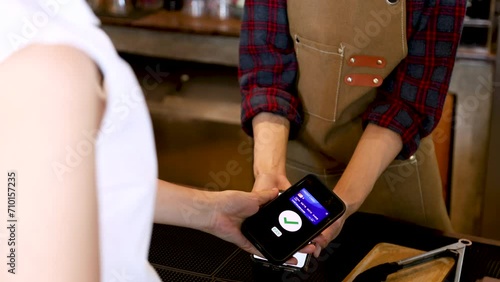 Closeup customer hand hold mobilephone making cashless payment in retails small business cafe coffee restaurant shop, cashier using qr code billing credit card, contactless online wireless application