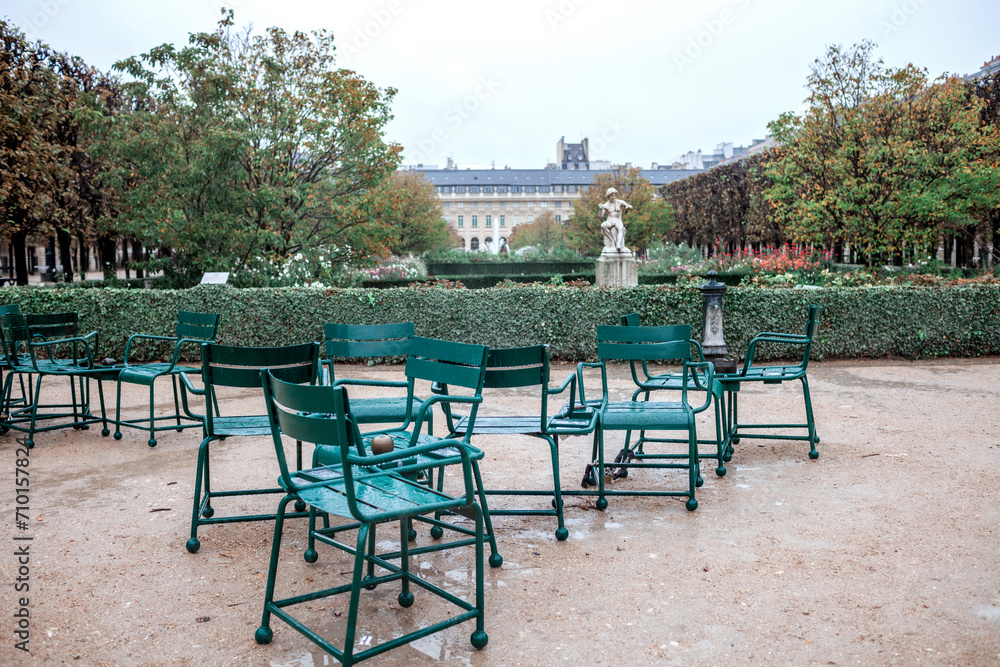 Autumn in The Tuileries Garden, Paris: Empty green chairs on a gravel path offer a quiet moment in the city heart, perfect for journey through French culture and history. Travel and trip concepts