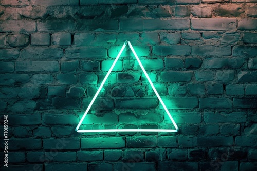 Green neon light triangle on block wall, conceptual illustration.