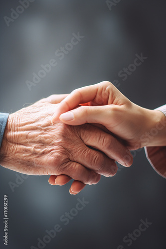 Taking care of the elderly concept with young woman holding the hand of a senior