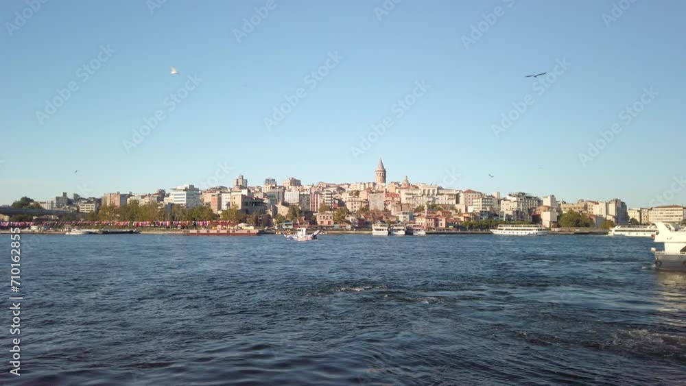 Daytime, a view from the Eminonu Pier in Istanbul captures the cityscape of Beyoglu. Beyond the buildings, the Galata Tower is visible, and ferries are navigating the waters of the Golden Horn. Daytime, a view from the Eminonu Pier in Istanbul captures the cityscape of Beyoglu. Beyond the buildings, the Galata Tower is visible, and ferries are navigating the waters of the Golden Horn.