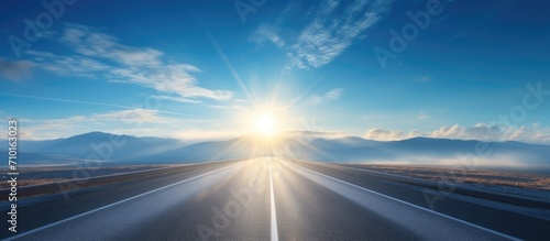 Hazy road and blue sky with a bright sun