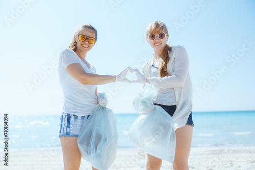 eco activists collecting garbage and showing heart shaped hands photo