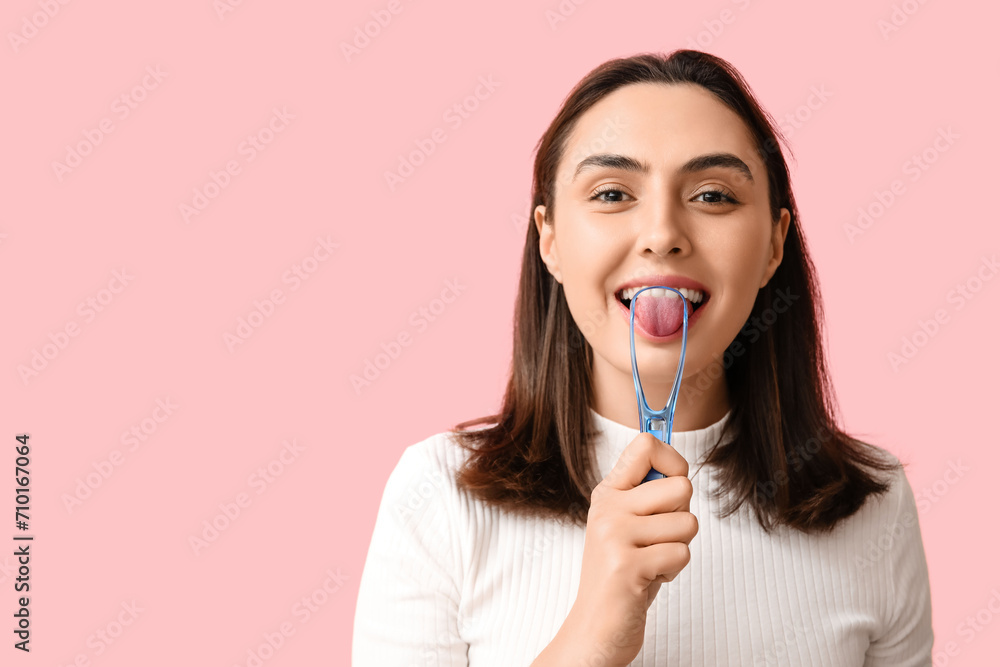Young woman using tongue scraper on pink background, closeup Young woman using tongue scraper on pink background, closeup