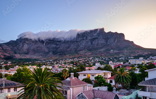 Obraz na płótnie Table Mountain peak covered with cloud and suburb nestled on the foothills of Table Mountainat during sunset, Cape Town, South Africa w salonie