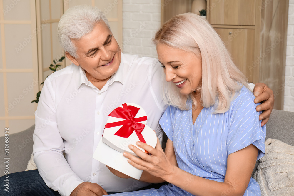 Mature woman with gift from her beloved husband at home Mature woman with gift from her beloved husband at home