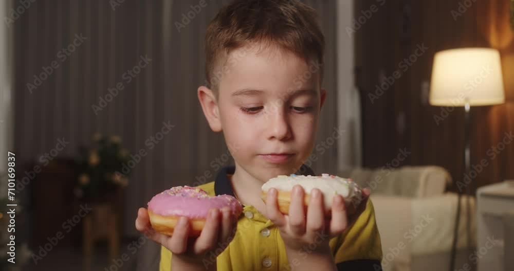 Portrait caucasian child 7 years old eats an appetizing sweet dessert donuts in glaze. Cheerful little boy eats a sweet donut. Close-up of the mouth of a child eating sweet pastries. 4K. Portrait caucasian child 7 years old eats an appetizing sweet dessert donuts in glaze. Cheerful little boy eats a sweet donut. Close-up of the mouth of a child eating sweet pastries. 4K.