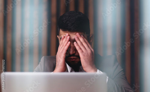 businessman with hands behind head resting in comfortable office.