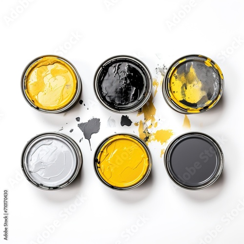 The used paint cans. Jars with yellow, black and gray paint on a white background. Cans with yellow, grey and black paint , top view. 6 cans of professional paint for stylish repairs.