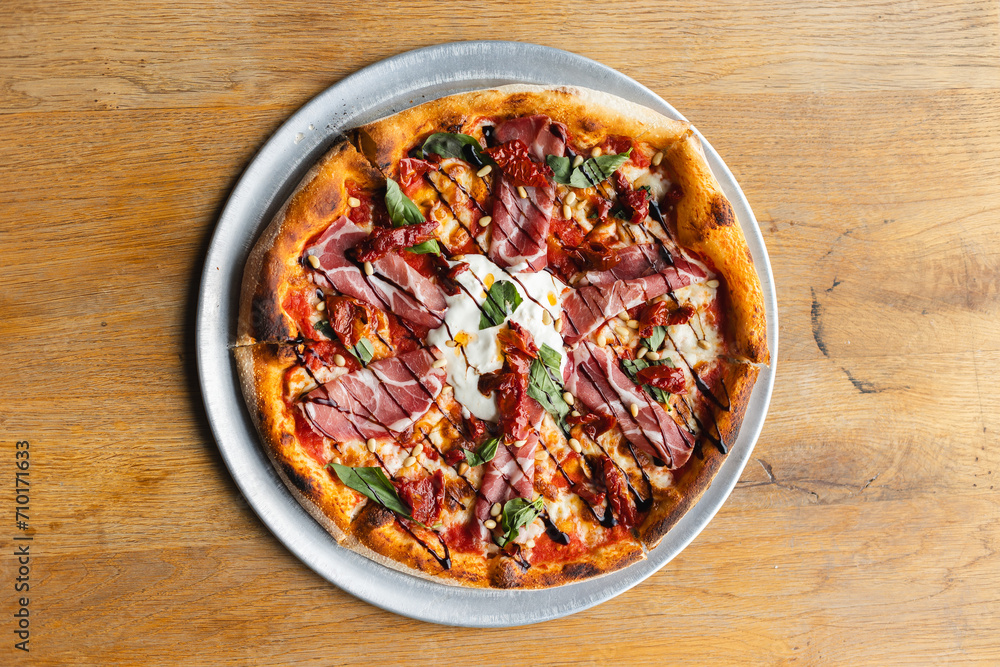 Appetizing pizza with tomato sauce, meat, basil and cheese. Appetizing pizza with tomato sauce, meat, basil and cheese.