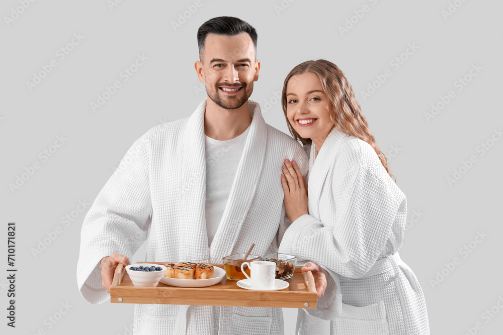 Young couple with tasty breakfast on light background. Valentine's Day celebration Young couple with tasty breakfast on light background. Valentine's Day celebration
