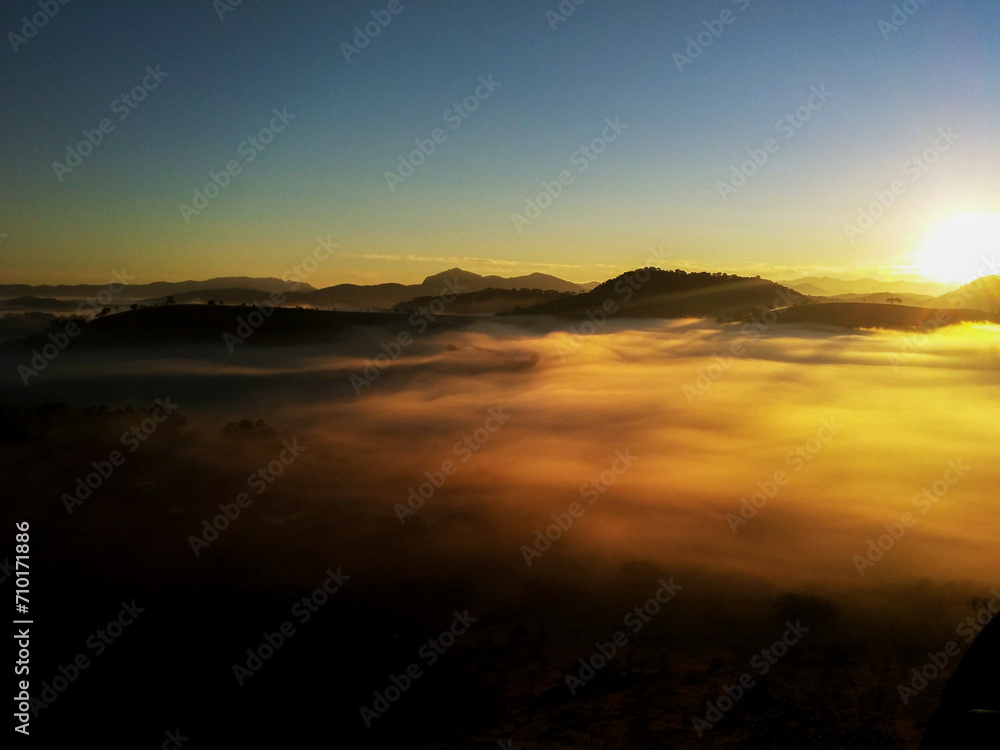 Mystical Sunrise Amidst Mountains and Mist
