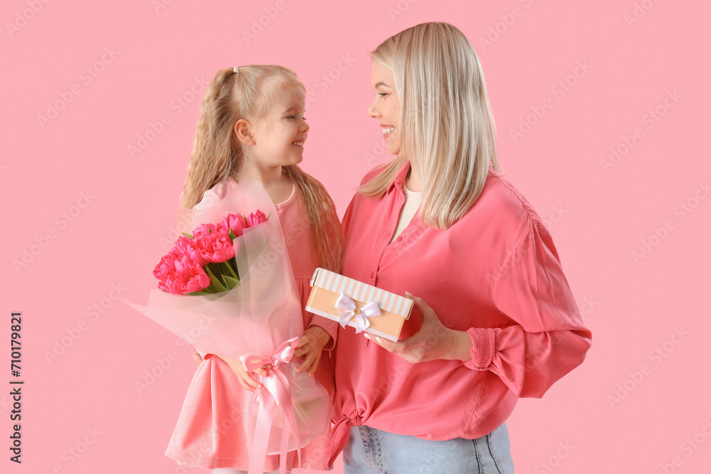 Little girl with her mother and gifts on pink background. International Women's Day celebration Little girl with her mother and gifts on pink background. International Women's Day celebration