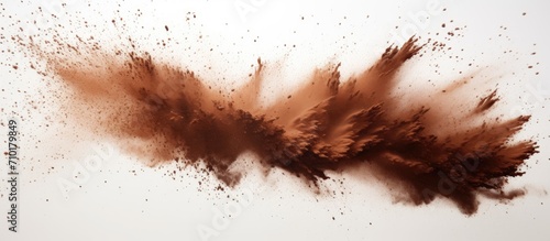 Brown dust bursts on white backdrop. photo