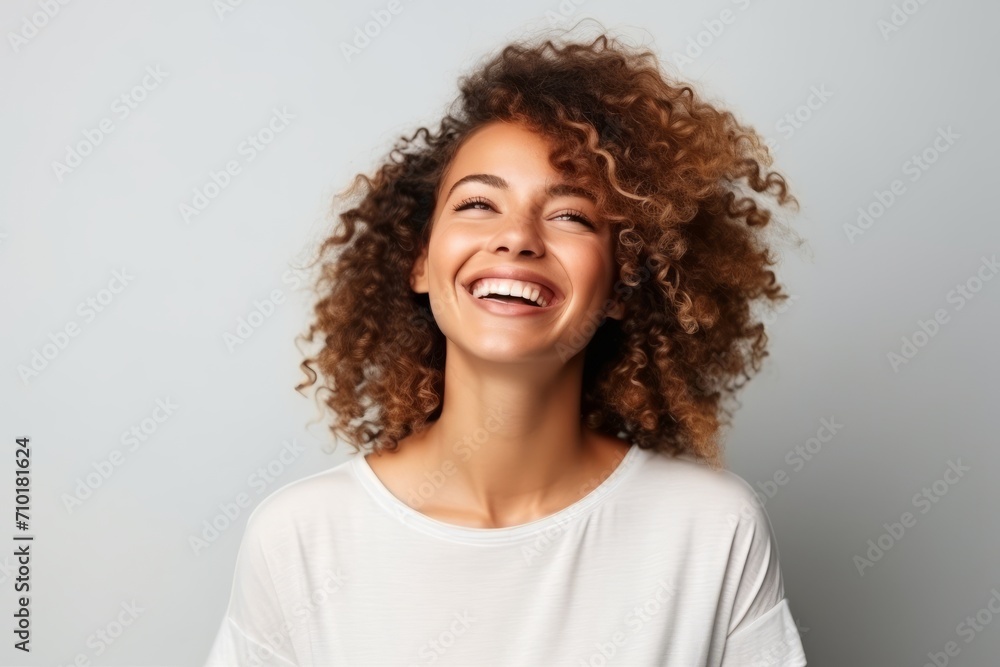Portrait of a beautiful young african american woman laughing against grey background Portrait of a beautiful young african american woman laughing against grey background