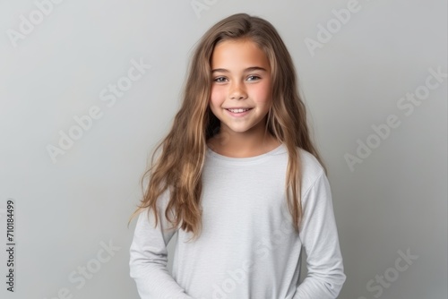 Portrait of a cute little girl with long hair on gray background © Iigo
