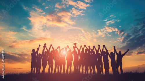 Success of teamwork, joint achievement of goal in business and life. Winning team is holding trophy in hands. Silhouettes of many hands in sunset.