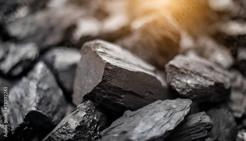 natural black coals in dark low lighting, symbolizing industrial strength and energy, perfect for backgrounds and conceptual designs