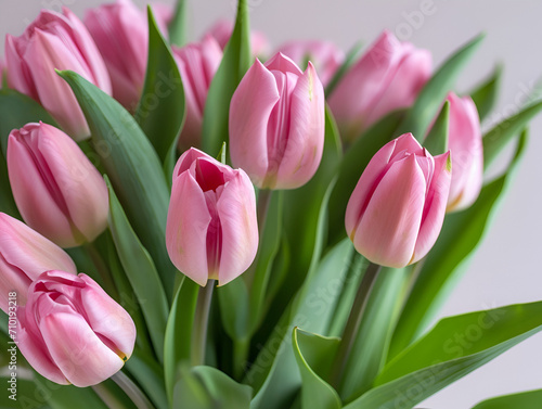 Bunch of pink spring flowers with green leaves at home  light beautiful purple tulips bouquet as nice romantic present from floral shop made by professional florist  vertical close up view copy space