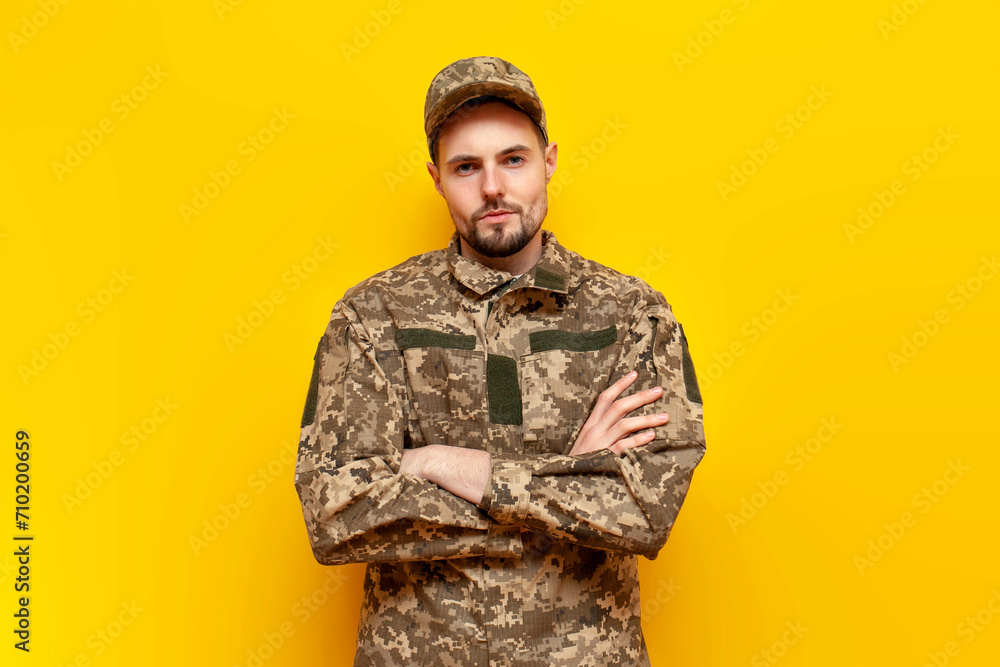 young Ukrainian male soldier in camouflage pixel uniform stands with ...