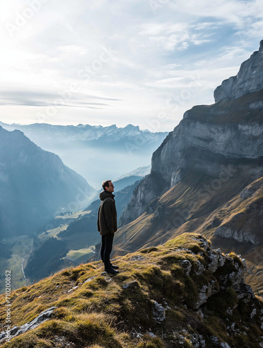 Ein Mann steht auf einem Berg in den Schweizer Alpen und schaut zuversichtlich in die Landschaft