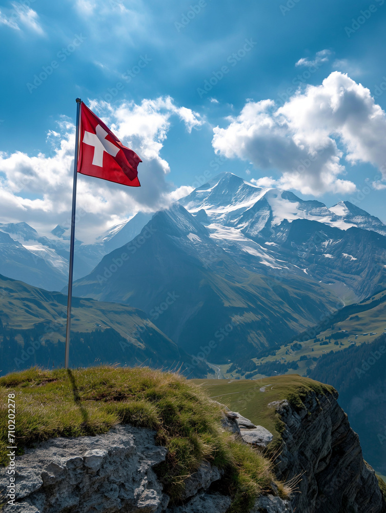Die Schweizer Flagge auf dem Gipfel eines Berges in den Schweizer Alpen mit einem herrlichen Panorama im Hintergrund Die Schweizer Flagge auf dem Gipfel eines Berges in den Schweizer Alpen mit einem herrlichen Panorama im Hintergrund