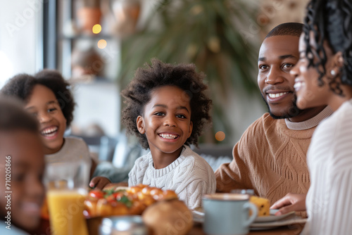 An African-American family having lunch at home  a child looks and smiles at the camera.