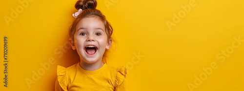 child smiling on a yellow studio background