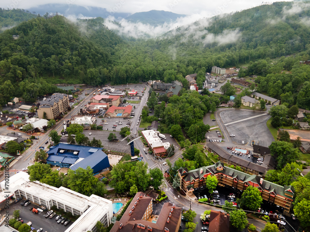 city of Gatlinburg in Tennessee and the Great Smoky Mountains from a bird's eye view, a tourist mecca with hotels, parking and shops.