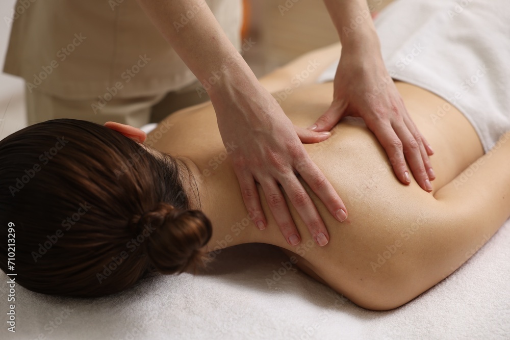 Woman receiving back massage on couch in spa salon Woman receiving back massage on couch in spa salon