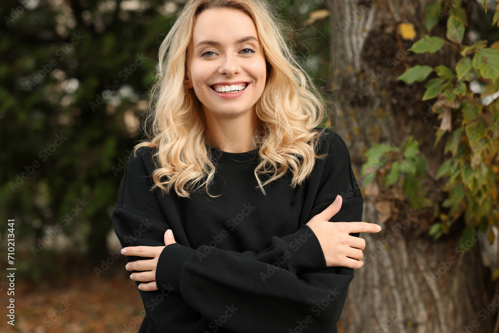 Happy woman in stylish warm sweater near tree outdoors Happy woman in stylish warm sweater near tree outdoors