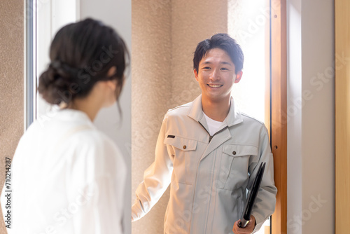 Canvas Print 顧客の家に上がる作業服姿の男性業者と出迎える主婦（リフォーム・お邪魔します・アフターフォロー）