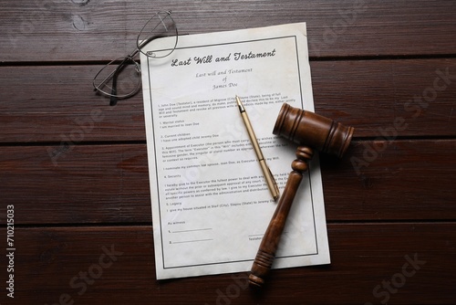 Last Will and Testament with glasses, gavel and pen on wooden table, flat lay
