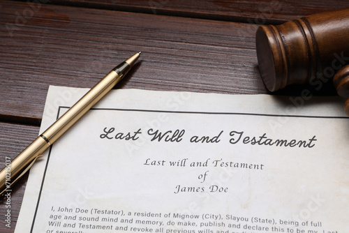 Last Will and Testament with gavel and pen on wooden table, closeup photo