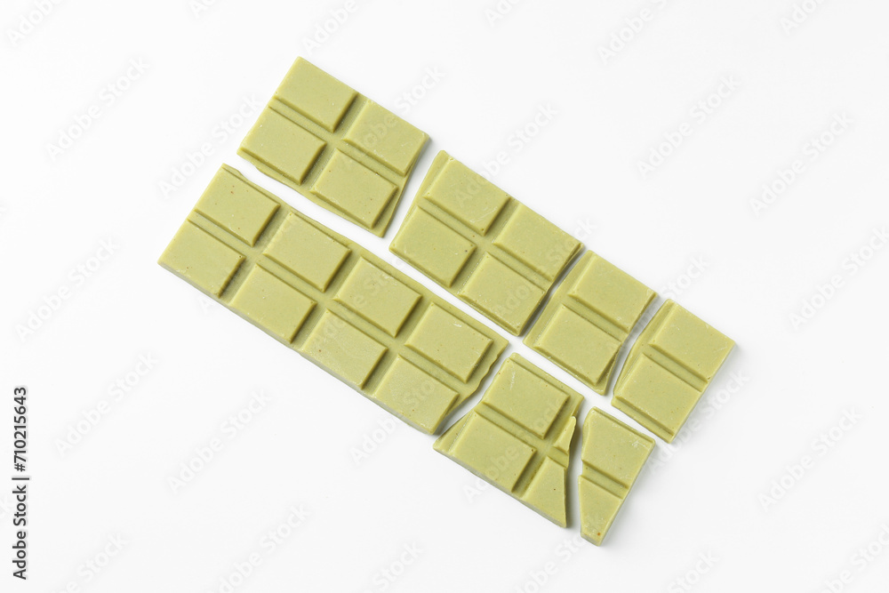 Pieces of tasty matcha chocolate bars on white background, top view