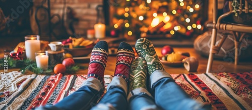 Three pairs of feet of a family sitting on the floor during a cozy December feast. photo