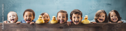 A row of cheerful faces as cute kids,  in a row,  engage in a joyful game of duck,  duck,  goose photo