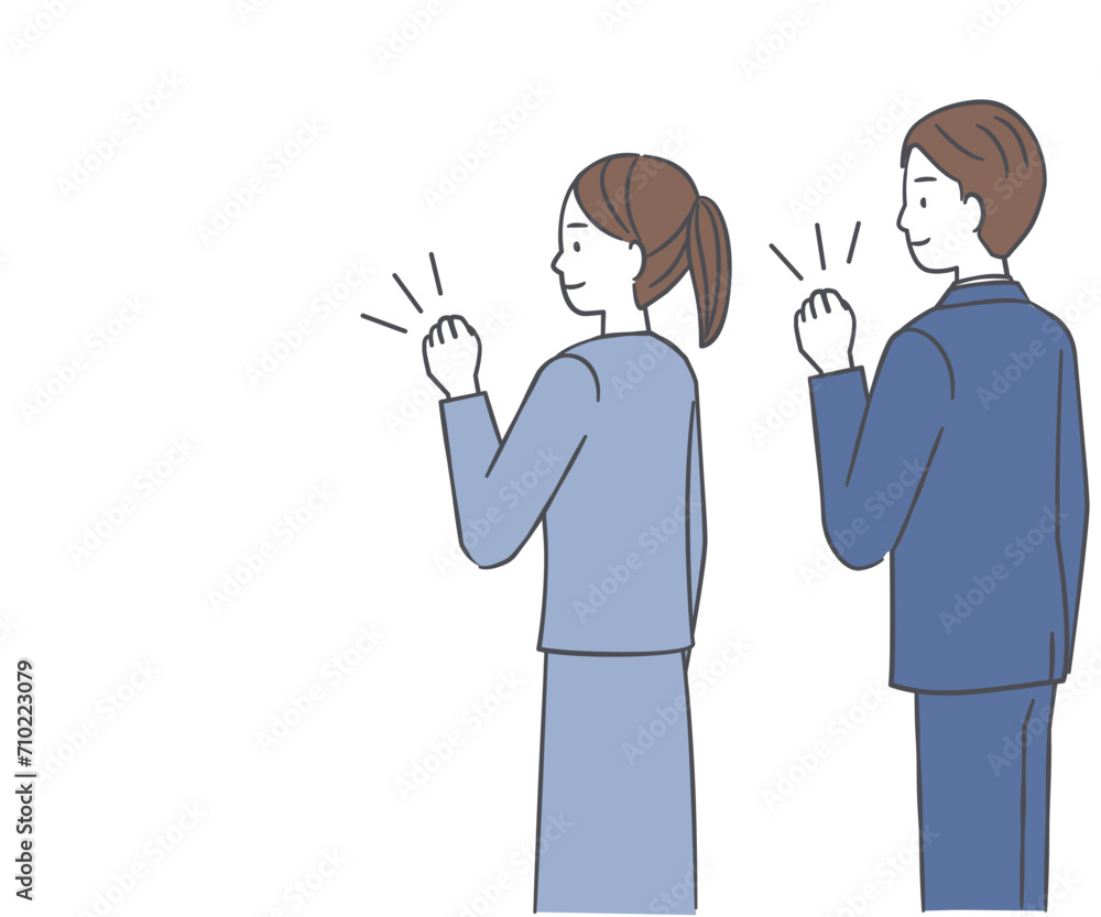 ガッツポーズをするスーツ姿の男性と女性