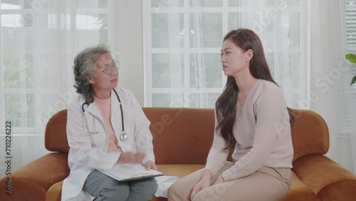 Asian doctor woman visited patient woman to diagnosis and check up health at home or private hospital. Female patient explain health problem and symptoms to doctor .Health care premium service at home photo