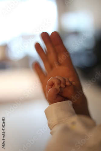 hands of baby holding moms hands